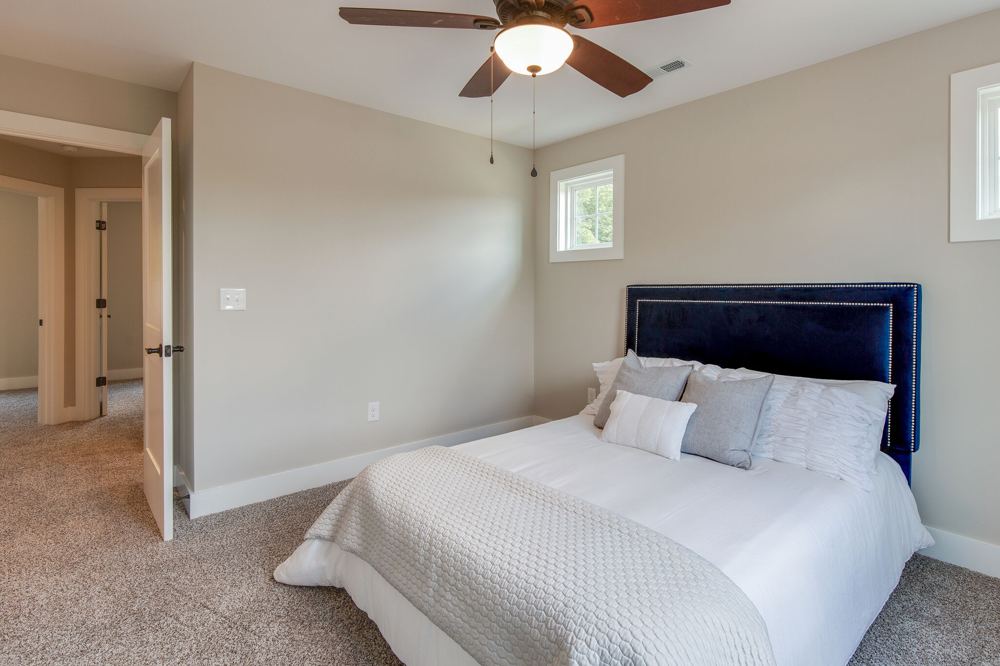 1026 Sycamore Ridge East, Unit 44 Burns, TN 37029 - Photo 20 of 28 a bedroom with a large bed and a chandelier