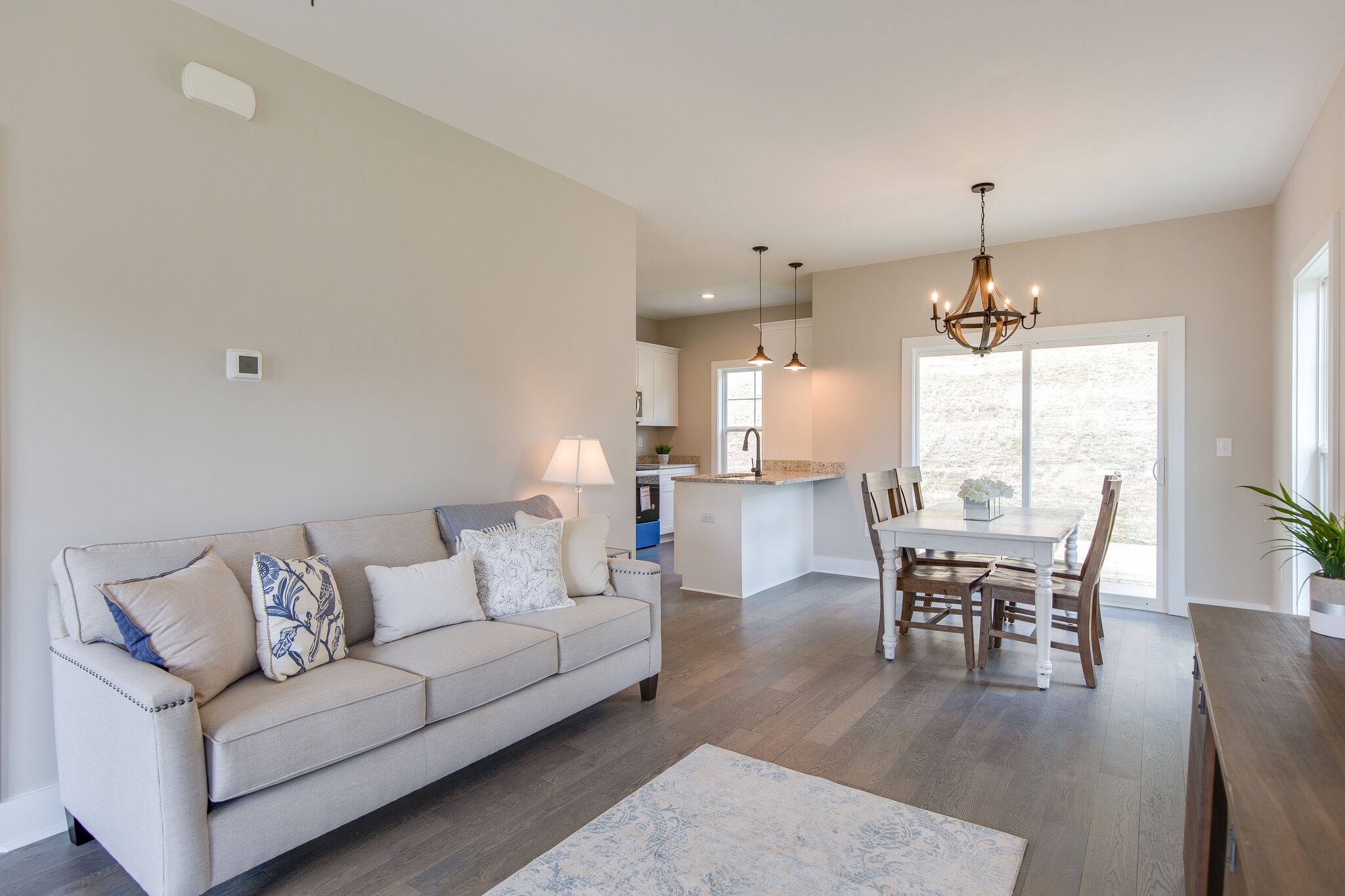 1026 Sycamore Ridge East, Unit 44 Burns, TN 37029 - Photo 9 of 28 a living room with furniture a dining table and a chandelier