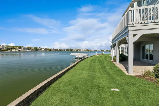 a view of a lake with a big yard and large trees