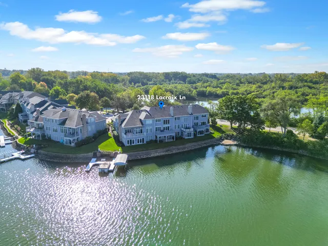 an aerial view of a house with swimming pool and lake view