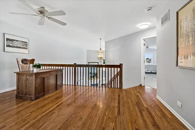 a view of a hallway with wooden floor and staircase