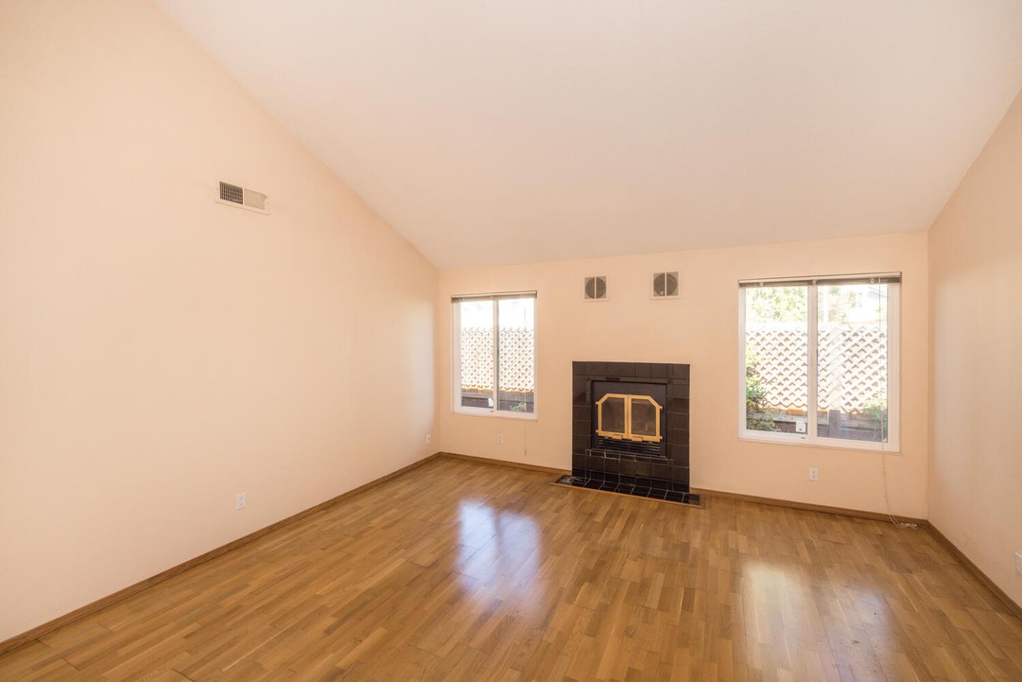 1170 Rickover Lane Foster City, CA 94404 - Photo 5 of 45 an empty room with wooden floor fireplace and windows