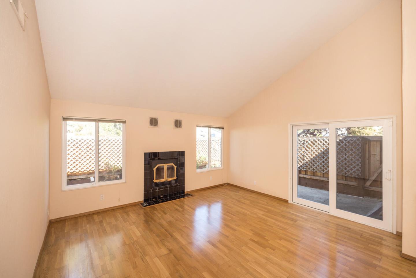 1170 Rickover Lane Foster City, CA 94404 - Photo 6 of 45 an empty room with wooden floor fireplace and windows