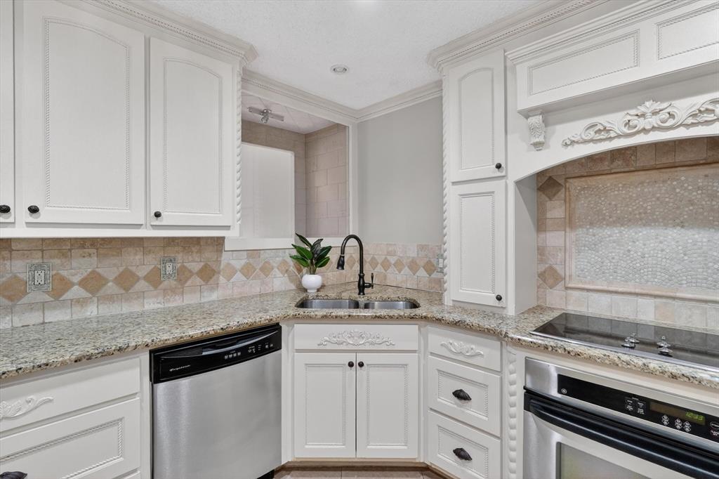 272 Lodge Road Coppell, TX 75019 - Photo 8 of 24 a kitchen with granite countertop white cabinets and white appliances