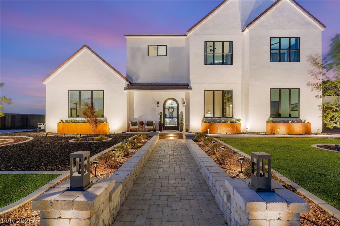 324 Wanda Road Henderson, NV 89002 - Photo 7 of 96 An inviting stone walkway leads directly to the arched glass entrance of this modern home.