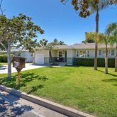 a view of a house with backyard and sitting area