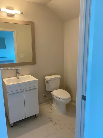 a bathroom with a sink toilet and mirror