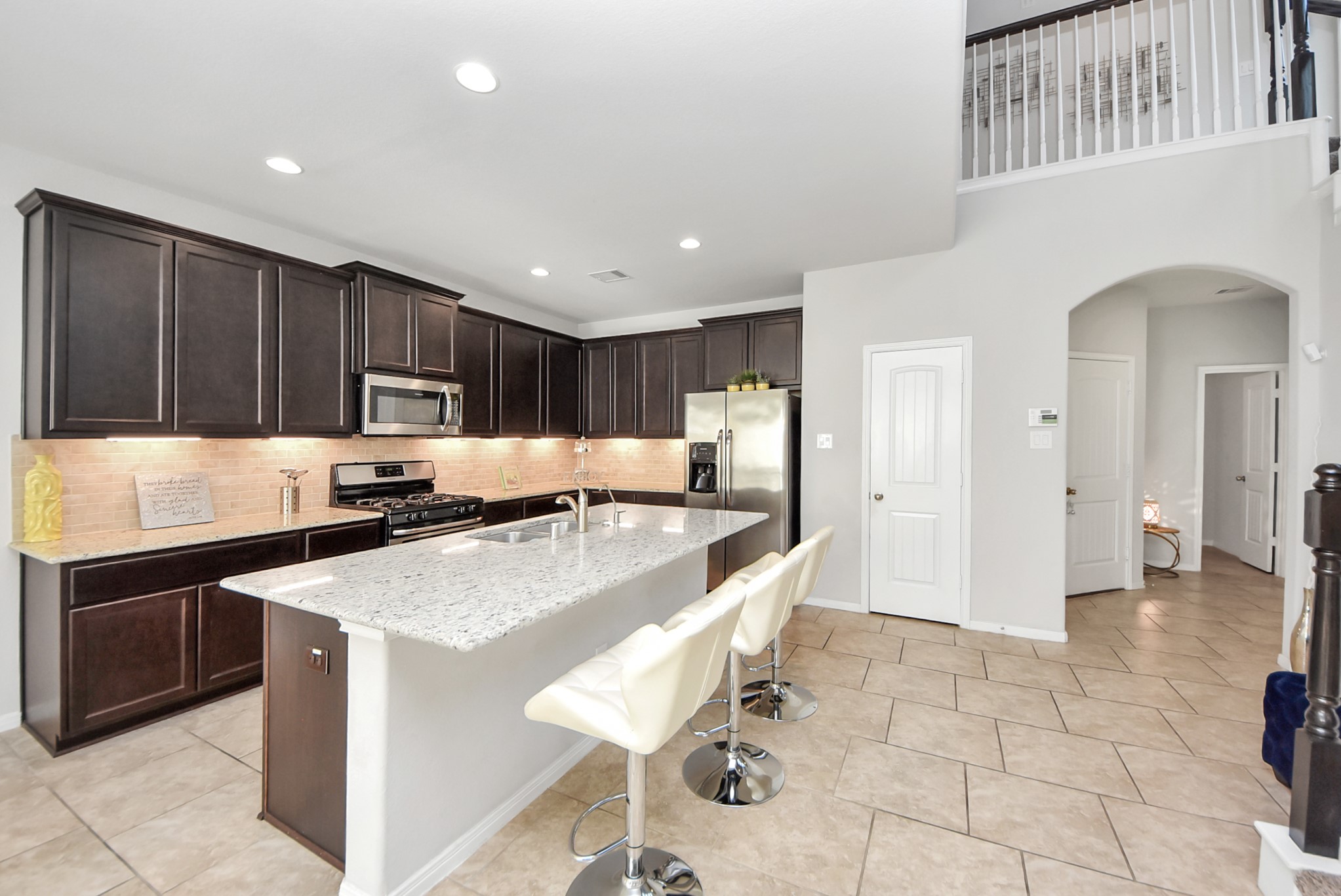 3310 Rainflower Springs Lane Rosenberg, TX 77471 - Photo 14 of 31 Beautiful kitchen with a large island, modern appliances, and dark wood cabinets, perfect for meal prep and casual dining.