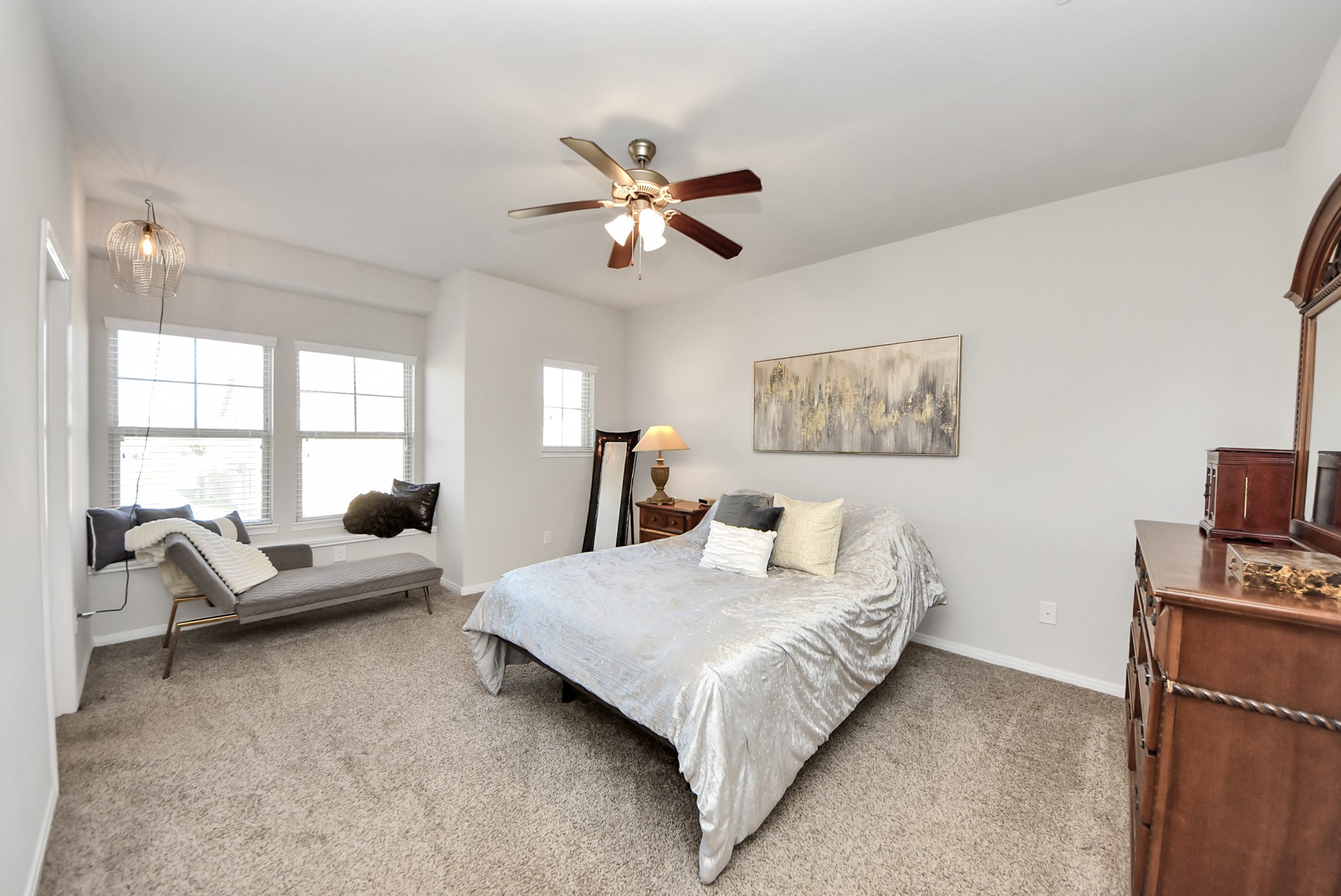 3310 Rainflower Springs Lane Rosenberg, TX 77471 - Photo 16 of 31 Elegant master bedroom with a large window nook, neutral tones, and comfortable carpet flooring, creating a peaceful retreat.