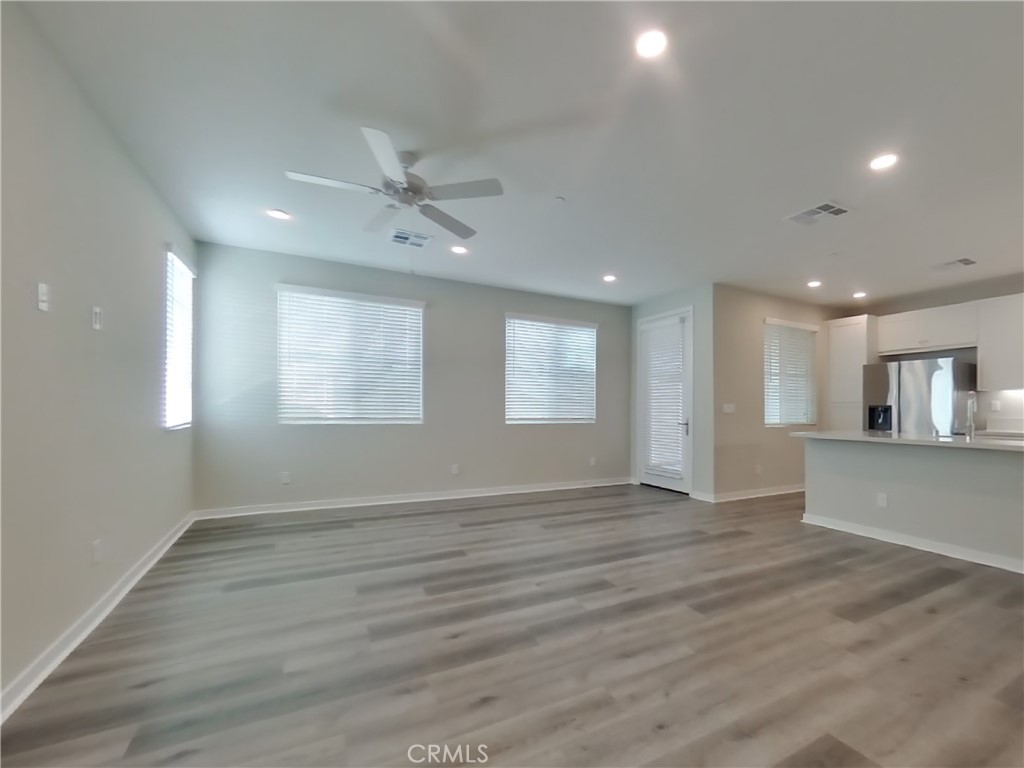 31727 Willowood Way Menifee, CA 92584 - Photo 4 of 31 a view of an empty room with wooden floor and a window