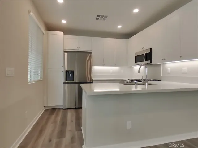 a kitchen with kitchen island a sink stove and refrigerator