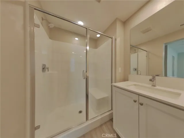 a bathroom with a shower sink vanity and mirror