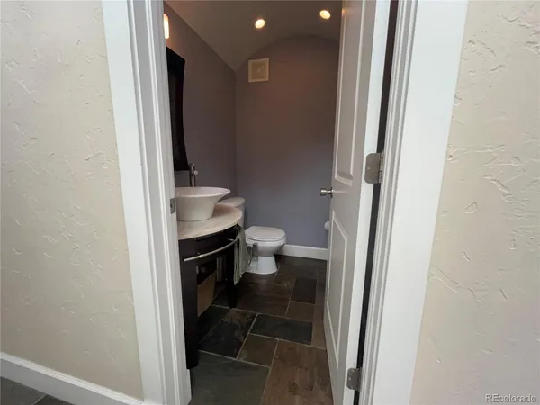 a bathroom with a granite countertop toilet and a sink