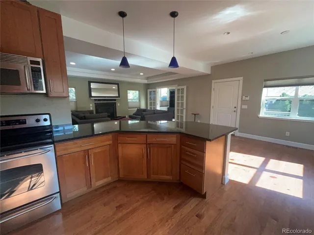 a kitchen with stainless steel appliances granite countertop a stove a sink and a wooden floors