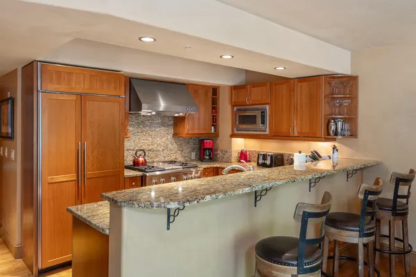 a kitchen with stainless steel appliances granite countertop a sink refrigerator and cabinets