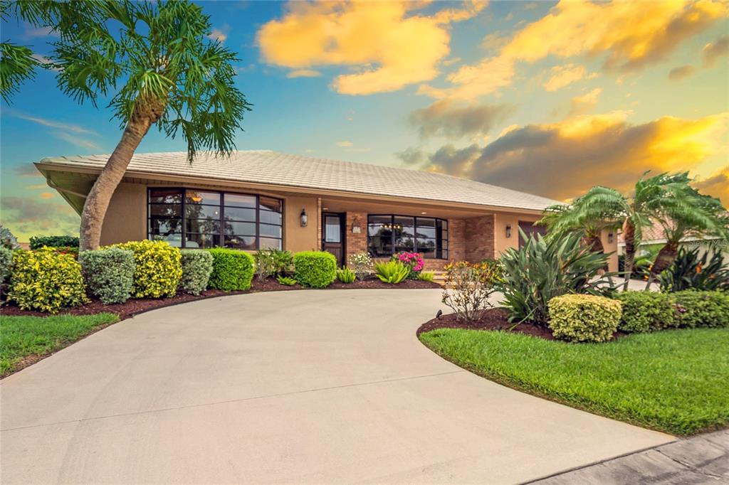 a front view of a house with a yard and potted plants