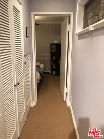 a view of a hallway and a livingroom with furniture