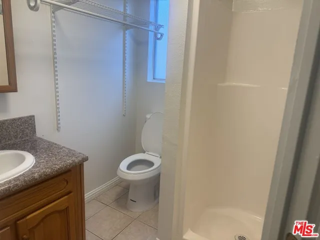 a bathroom with a granite countertop sink toilet and a mirror