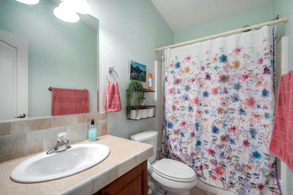 18218 Paradise Mountain Road Valley Center, CA 92082 - Photo 19 of 36 a bathroom with a sink toilet and a mirror
