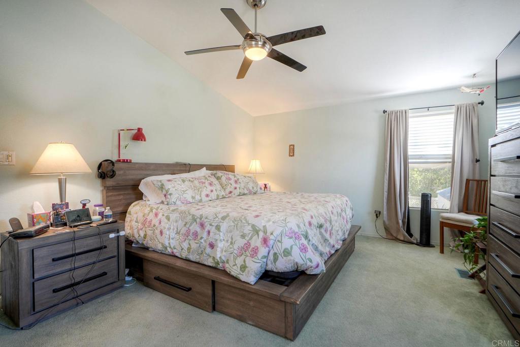 18218 Paradise Mountain Road Valley Center, CA 92082 - Photo 23 of 36 a bedroom with a bed and a chandelier