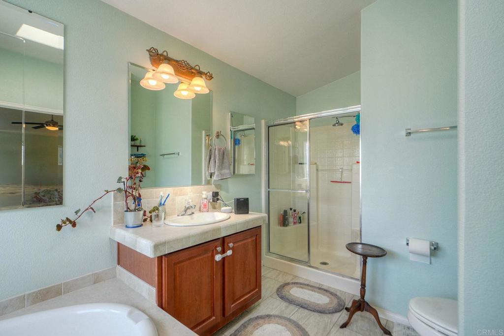18218 Paradise Mountain Road Valley Center, CA 92082 - Photo 27 of 36 a bathroom with a sink double vanity granite tub and shower