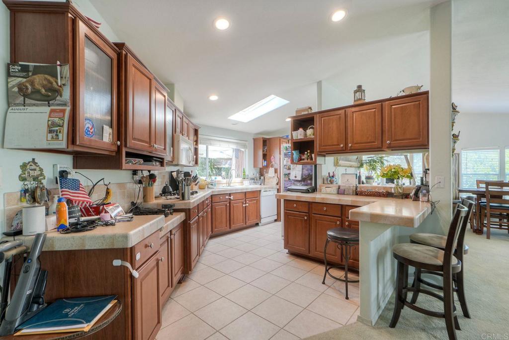18218 Paradise Mountain Road Valley Center, CA 92082 - Photo 9 of 36 a kitchen with stainless steel appliances granite countertop a stove a sink dishwasher and a refrigerator with wooden cabinets