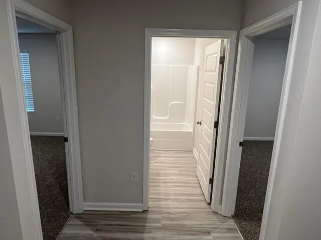 a view of a hallway with wooden floor and staircase