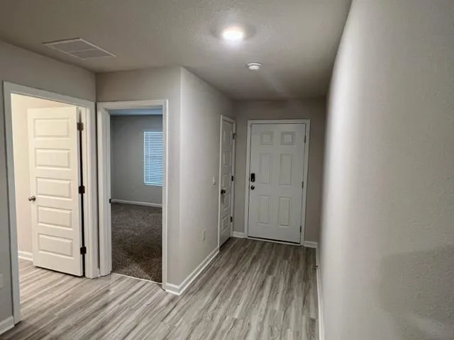 a view of a hallway with wooden floor