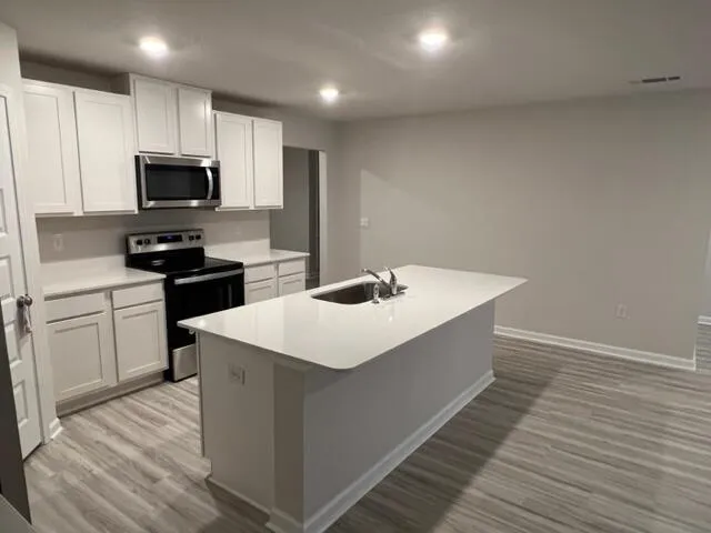 a kitchen with kitchen island sink stove and refrigerator