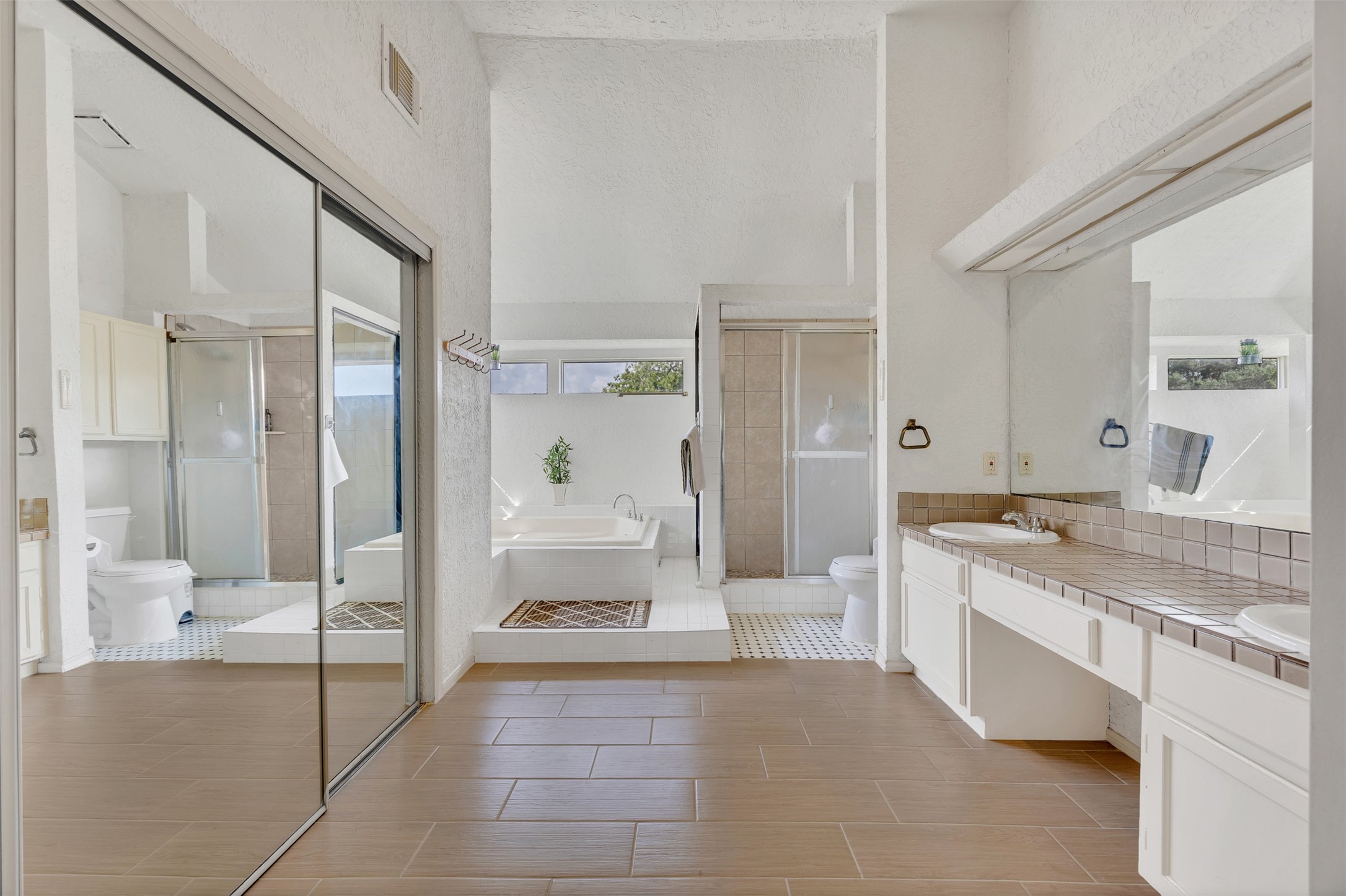 15619 Beechnut Street Houston, TX 77083 - Photo 22 of 29 Large en suite bathroom with double vanities, tile flooring, and abundant natural light.