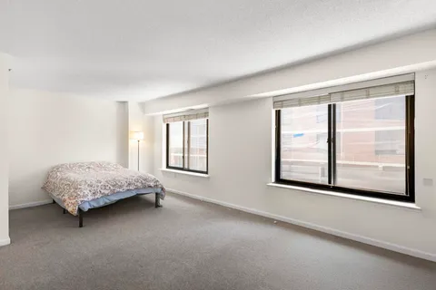 a bedroom with a bed and a large window