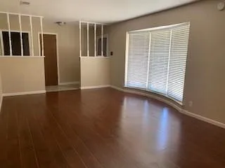 a view of a livingroom with wooden floor and a window