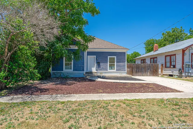 a view of a house with backyard and a tree