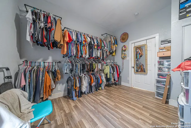 a view of walk in closet with clothes and shoes