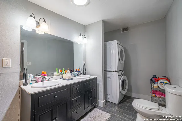 a bathroom with a sink vanity mirror and toilet