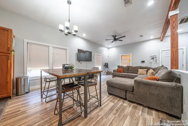 a living room with furniture a chandelier and a flat screen tv