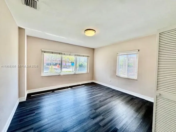 a view of empty room with wooden floor