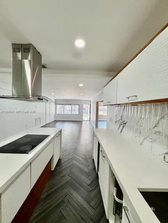 a kitchen with a sink a stove and cabinets