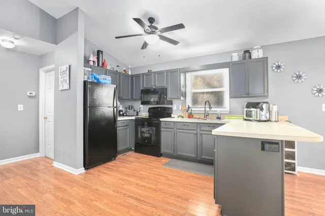 a kitchen with a refrigerator sink and cabinets
