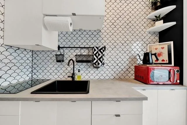 a kitchen with a sink a stove and cabinets