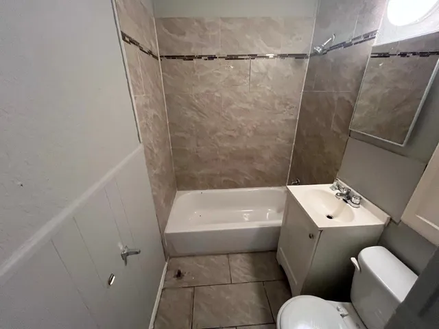 a white toilet sitting next to a bath tub