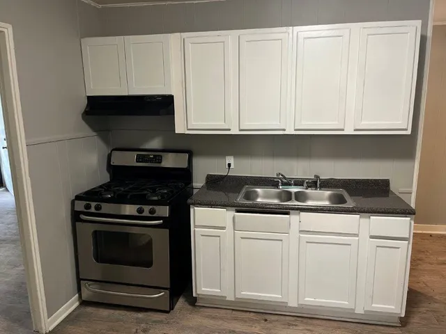 a kitchen with granite countertop white cabinets and stainless steel appliances