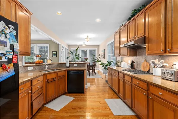 a kitchen with stainless steel appliances granite countertop a stove a sink dishwasher and a refrigerator