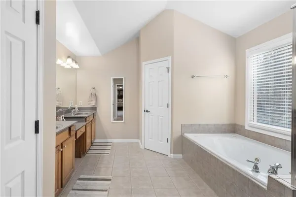 a en suite bathroom with a double vanity sink and a mirror
