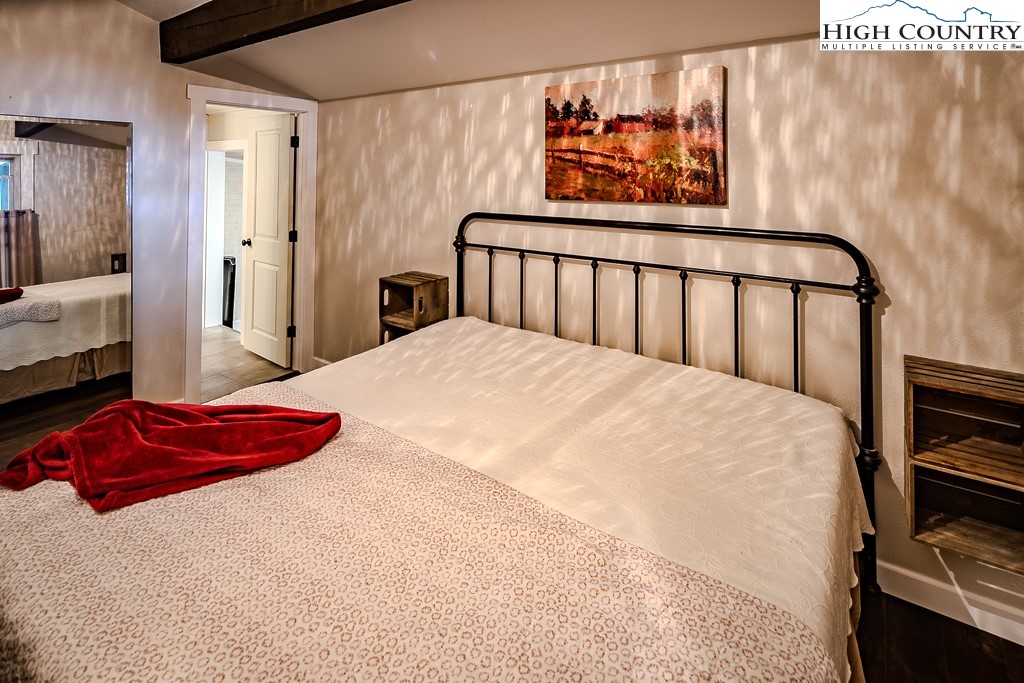 821 Pine Ridge Road Beech Mountain, NC 28604 - Photo 20 of 38 a bedroom with a bed and a painting on the wall