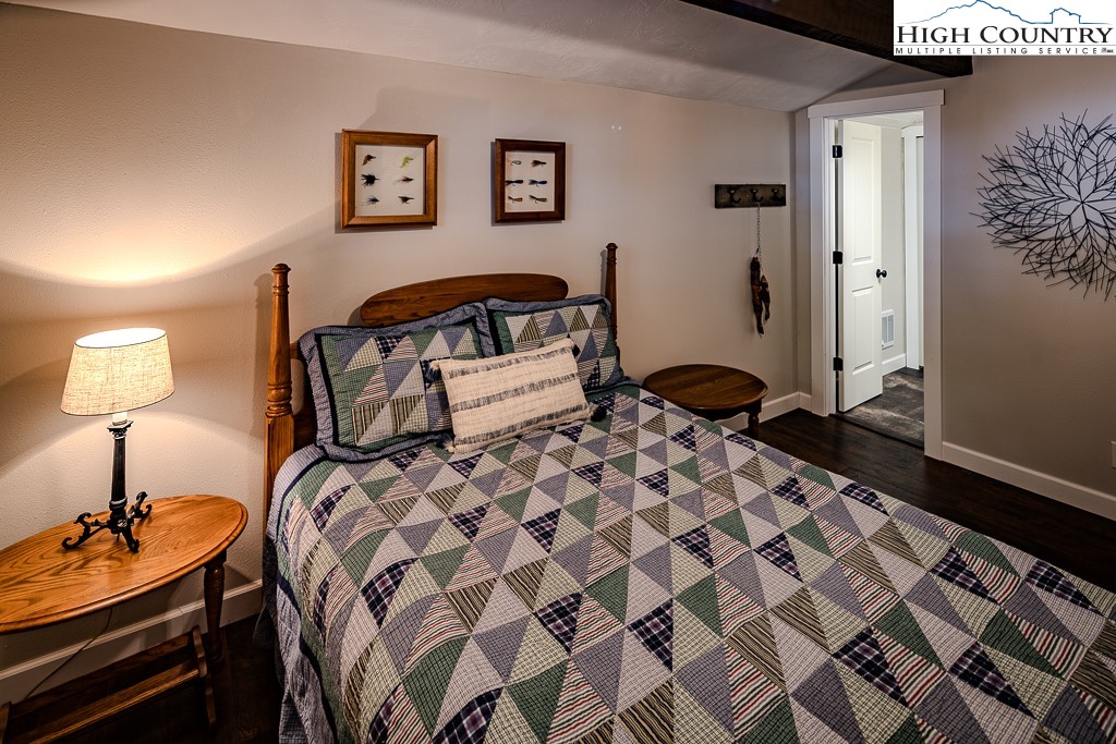 821 Pine Ridge Road Beech Mountain, NC 28604 - Photo 27 of 38 a bedroom with a bed and a lamp