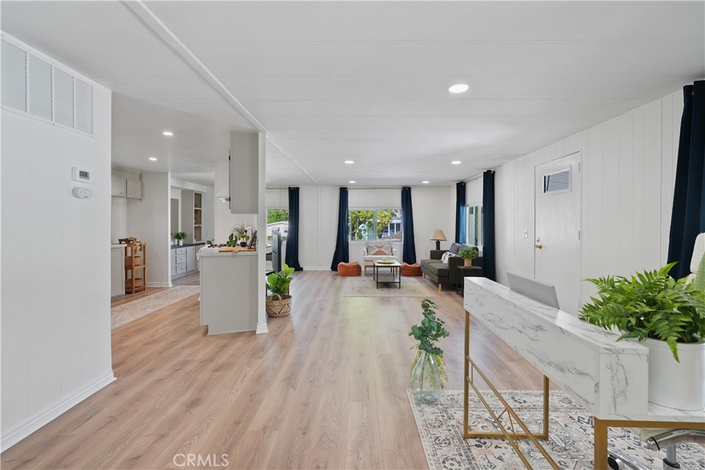 a view of a living room and kitchen with furniture and wooden floor