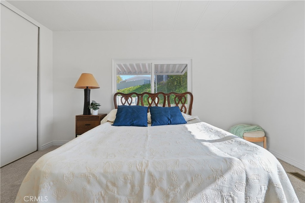 31130 South General Kearny Road, Unit 136 Temecula, CA 92591 - Photo 42 of 65 a bed sitting in a bedroom next to a lamp