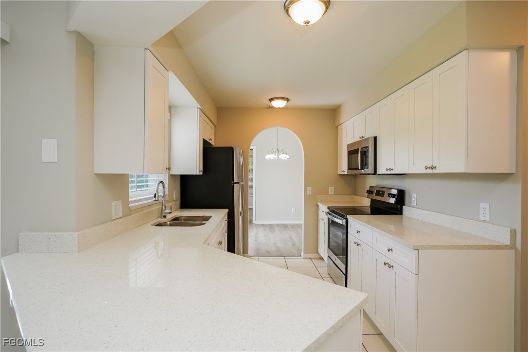 18257 Columbine Road Fort Myers, FL 33967 - Photo 7 of 16 a kitchen with a stove a sink and a refrigerator