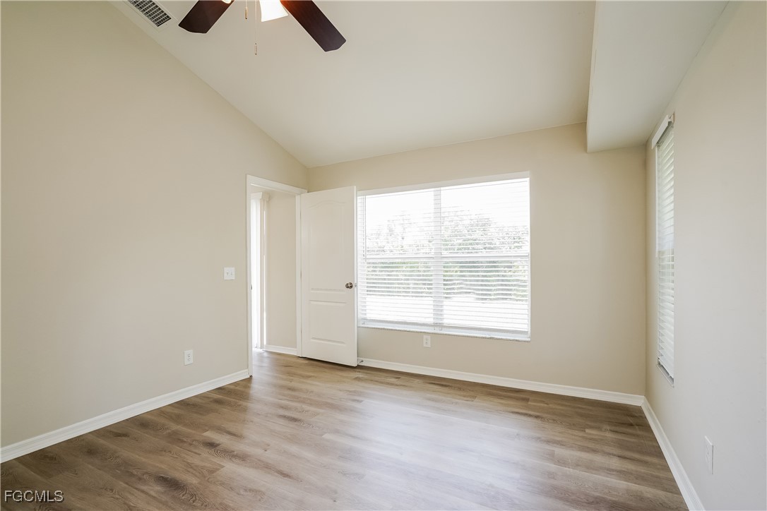18257 Columbine Road Fort Myers, FL 33967 - Photo 9 of 16 an empty room with wooden floor cabinet and windows